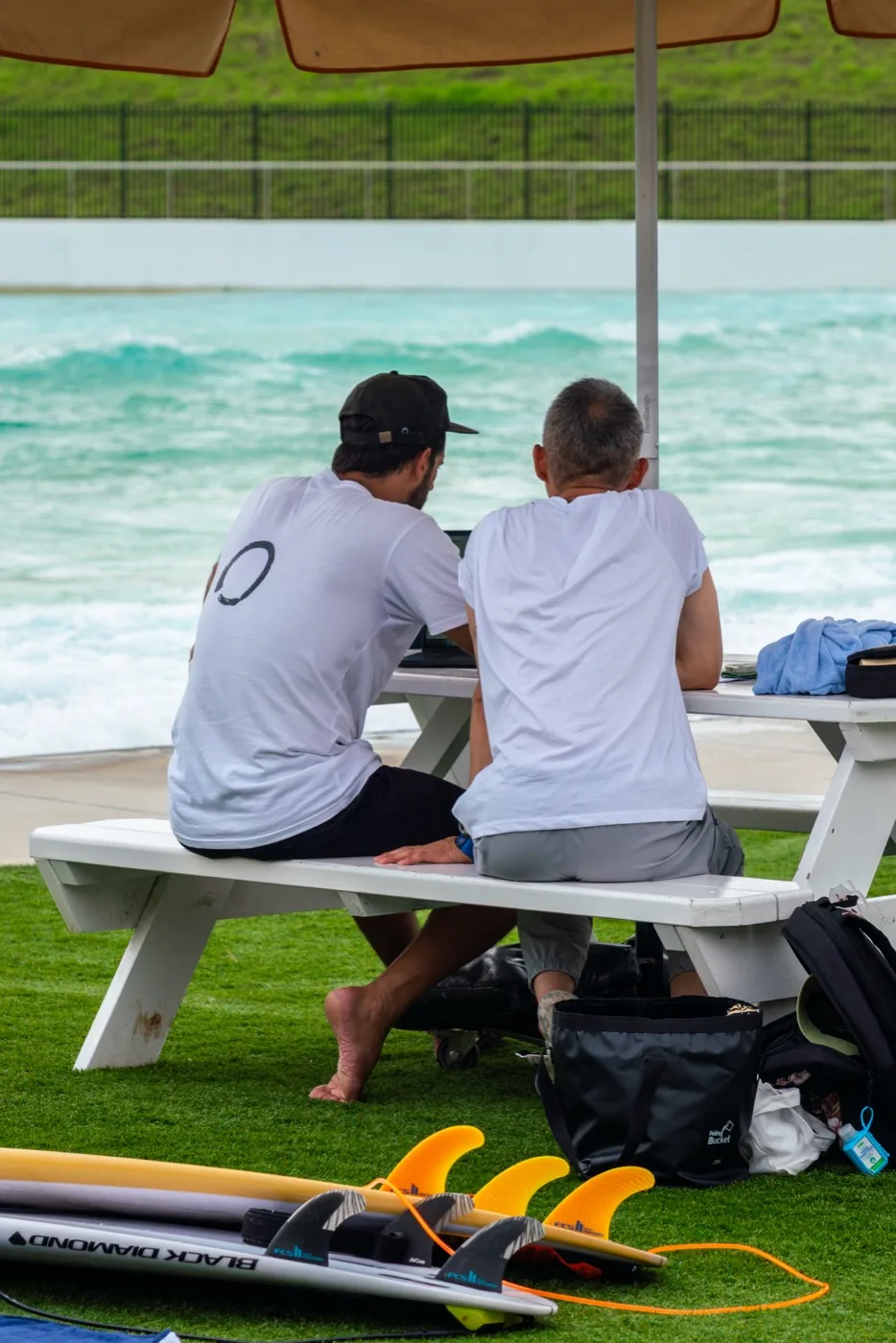 Coach and surfer reviewing a session beside the water